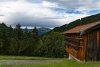 EIne kleine Scheune im Vordergrund und Berge am Horizont